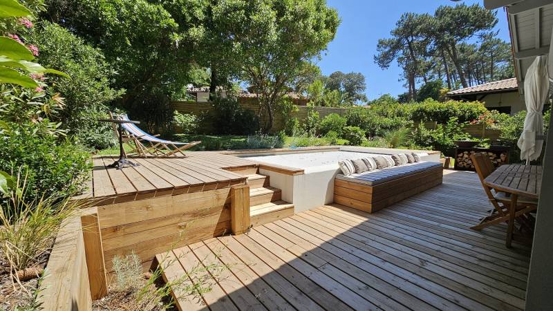 Terrasse en lames de résineux haut de gamme autour d'une piscine avec banquettes au Pyla sur mer (33)